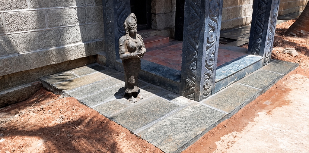 Stone porch with natural stone paving and statue